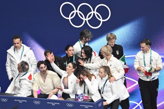 Italy's Sara Conti (CR) and Italy's Niccolo Macii (CL) react in the kiss and cry area after competing in the figure skating pair free skating team event during the Milano Cortina 2026 Winter Olympic Games at Milano Ice Skating Arena in Milan on February 8, 2026. (Photo by Antonin THUILLIER / AFP)