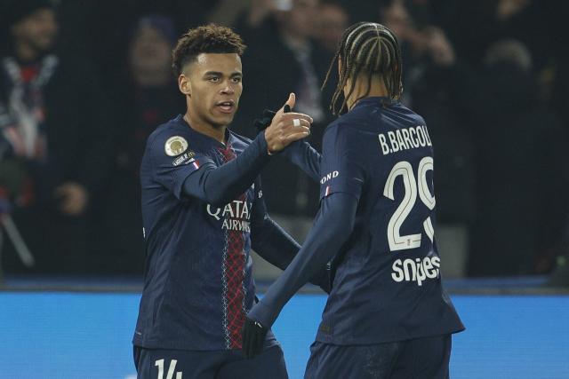 Paris Saint-Germain's French midfielder #14 Desire Doue (L) and Paris Saint-Germain's French forward #29 Bradley Barcola (R) celebrate their team's first goal during the French L1 football match between Paris Saint-Germain (PSG) and Olympique de Marseille (OM) at the Parc des Princes stadium in Paris on February 8, 2026. (Photo by GEOFFROY VAN DER HASSELT / AFP)