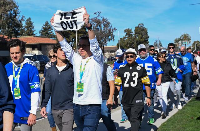A fan carries an "ICE Out" rally towel while walking to Levi's Stadium ahead of Super Bowl LX in Santa Clara, California on February 8, 2026. (Photo by Karl Mondon / AFP)