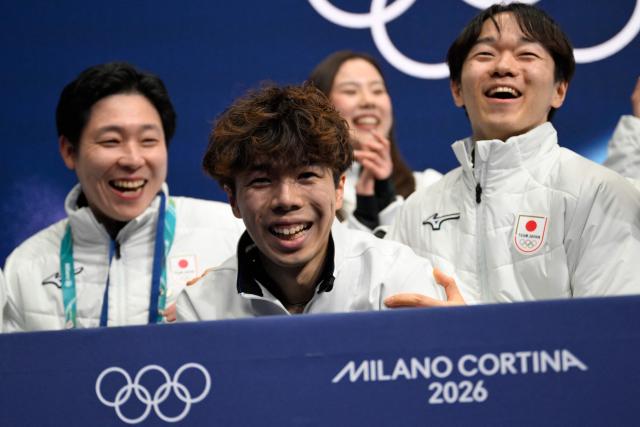 Japan's Shun Sato (C) reacts in the kiss and cry area after competing in the figure skating men's singles free skating team event during the Milano Cortina 2026 Winter Olympic Games at Milano Ice Skating Arena in Milan on February 8, 2026. (Photo by WANG Zhao / AFP)