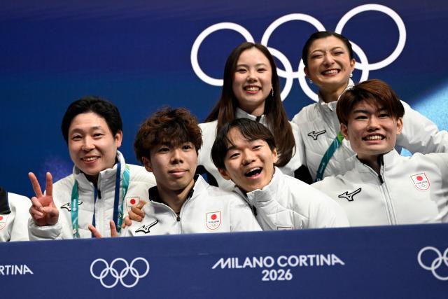 Japan's Shun Sato (2nd L) reacts in the kiss and cry area after competing in the figure skating men's singles free skating team event during the Milano Cortina 2026 Winter Olympic Games at Milano Ice Skating Arena in Milan on February 8, 2026. (Photo by WANG Zhao / AFP)