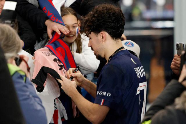 Paris Saint-Germain's Portuguese midfielder #17 Vitinha (C) signs a shirt for supporters at the end of the French L1 football match between Paris Saint-Germain (PSG) and Olympique de Marseille (OM) at the Parc des Princes stadium in Paris on February 8, 2026. (Photo by GEOFFROY VAN DER HASSELT / AFP)