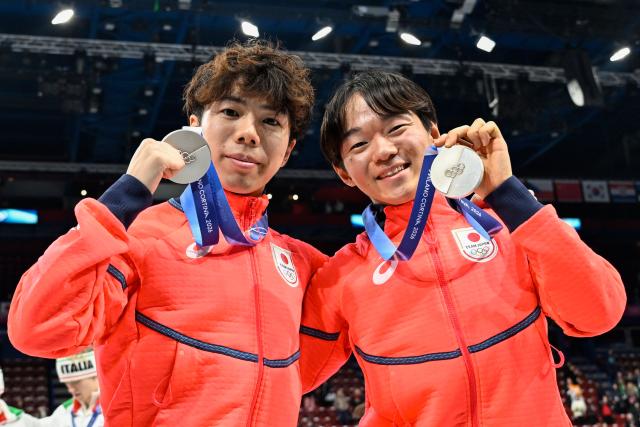 Silver medallists Japan's Shun Sato and Japan's Yuma Kagiyama pose with their medals following the podium ceremony of the figure skating team event during the Milano Cortina 2026 Winter Olympic Games at Milano Ice Skating Arena in Milan on February 8, 2026. (Photo by WANG Zhao / AFP)