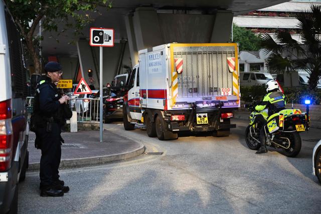 A police vehicle operated by the explosive ordnance disposal unit (C) passes by as police personnel work outside the West Kowloon Magistrates' Court in Hong Kong on February 9, 2026, ahead of the sentencing of convicted pro-democracy media tycoon Jimmy Lai. Hong Kong pro-democracy media tycoon Jimmy Lai will be sentenced on February 9 over national security crimes that could see him jailed for life, with some rights groups and Western nations still demanding his release. (Photo by Peter PARKS / AFP)