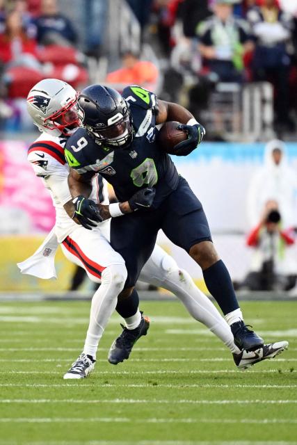 Seattle Seahawks’ running back #09 Kenneth Walker III tries to break away from New England Patriots’ cornerback #07 Carlton Davis III during Super Bowl LX between the New England Patriots and the Seattle Seahawks at Levi's Stadium in Santa Clara, California on February 8, 2026. (Photo by JOSH EDELSON / AFP)