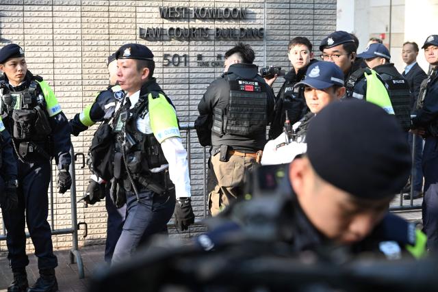 Police keep watch outside the West Kowloon Magistrates' court for the sentencing of convicted pro-democracy media tycoon Jimmy Lai in Hong Kong on February 9, 2026. Hong Kong pro-democracy media tycoon Jimmy Lai will be sentenced on February 9 over national security crimes that could see him jailed for life, with some rights groups and Western nations still demanding his release. (Photo by Peter PARKS / AFP)