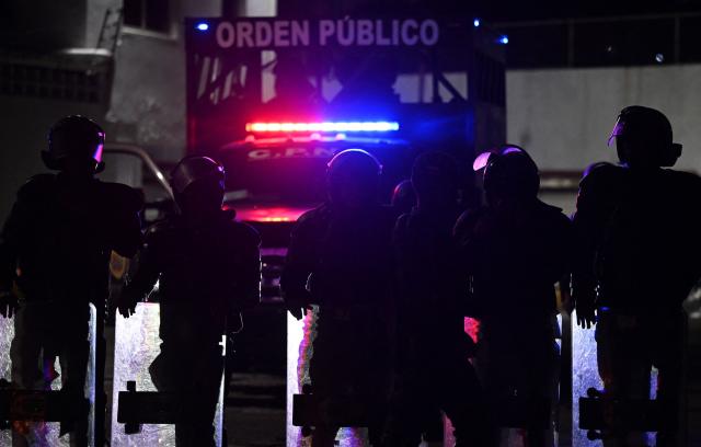 Venezuelan riot police guard a demonstration to demand the release of political prisoners outside Zona 7 prison in Caracas on February 8, 2026. Two opposition figures close to Venezuela's Nobel peace laureate Maria Corina Machado were freed from jail on February 8, 2026, one month after authorities began releasing political prisoners following the ouster of leader Nicolas Maduro. (Photo by Juan BARRETO / AFP)