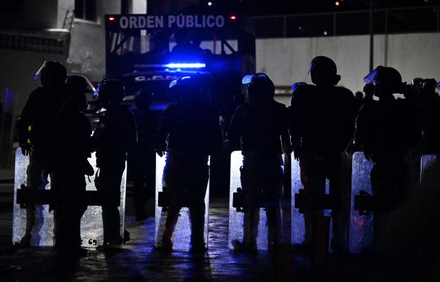 Venezuelan riot police guard a demonstration to demand the release of political prisoners outside Zona 7 prison in Caracas on February 8, 2026. Two opposition figures close to Venezuela's Nobel peace laureate Maria Corina Machado were freed from jail on February 8, 2026, one month after authorities began releasing political prisoners following the ouster of leader Nicolas Maduro. (Photo by Juan BARRETO / AFP)