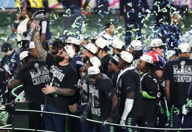 Seattle Seahawks' players celebrate with the Vince Lombardi Trophy after defeating the New England Patriots during Super Bowl LX at Levi's Stadium in Santa Clara, California on February 8, 2026. (Photo by Patrick T. Fallon / AFP)