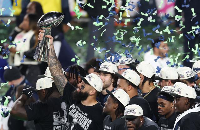 Seattle Seahawks' players celebrate with the Vince Lombardi Trophy after defeating the New England Patriots during Super Bowl LX at Levi's Stadium in Santa Clara, California on February 8, 2026. (Photo by Patrick T. Fallon / AFP)