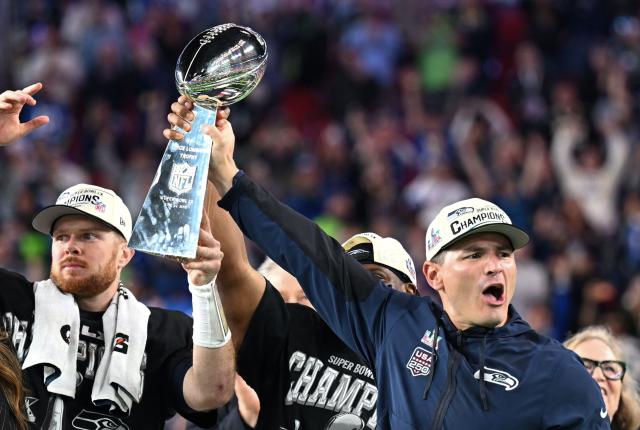 Seattle Seahawks’ quarterback #14 Sam Darnold and Seattle Seahawks' head coach Mike Macdonald celebrate with the Vince Lombardi Trophy after the Seattle Seahawks defeated the New England Patriots during Super Bowl LX at Levi's Stadium in Santa Clara, California on February 8, 2026. (Photo by JOSH EDELSON / AFP)