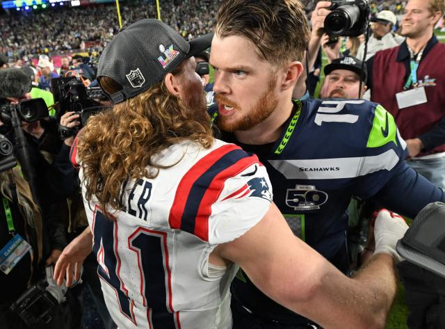 Seattle Seahawks’ quarterback #14 Sam Darnold and New England Patriots’ safety #41 Brenden Schooler hug after the Seattle Seahawks defeated the New England Patriots during Super Bowl LX at Levi's Stadium in Santa Clara, California on February 8, 2026. (Photo by JOSH EDELSON / AFP)