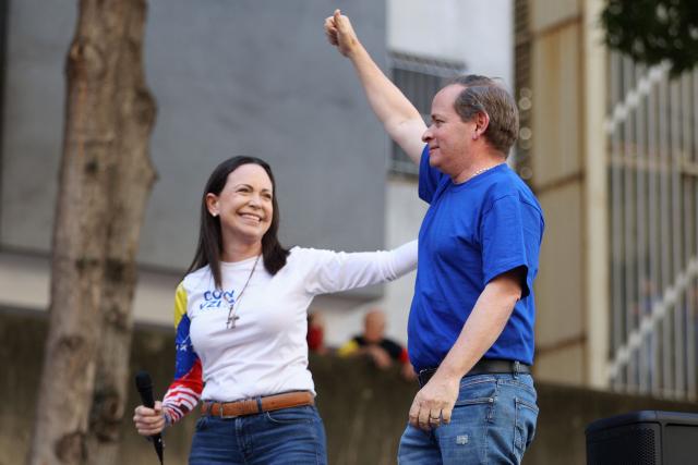 (FILES) Former Deputy of the National Assembly of Venezuela, Juan Pablo Guanipa (R), gestures next to Venezuelan opposition leader Maria Corina Machado during a protest called by the opposition on the eve of the presidential inauguration in Caracas on January 9, 2025. Venezuelan opposition leader and Nobel Peace Prize winner Maria Corina Machado denounced the "kidnapping" of political leader Juan Pablo Guanipa after he was released from prison on February 8, 2026, as part of a process of releasing political prisoners announced days after the overthrow of Nicolas Maduro. (Photo by Pedro MATTEY / AFP)
