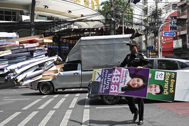 Bangkok Metropolitan Administration workers take down election posters a day after the general election in Bangkok on February 9, 2026. (Photo by Lillian SUWANRUMPHA / AFP)