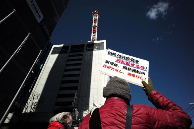 A participant holds a placard that reads "Do not restart the Kashiwazaki-Kariwa nuclear power plant! TEPCO lacks the technical expertise and qualifications to operate a nuclear power plant!" during a demonstration in front of Tokyo Electric Power Company's headquarters against the restart of the Kashiwazaki-Kariwa Nuclear Power Plant, in Tokyo on February 9, 2026. Japan switched on the world's biggest nuclear power plant again February 9, its operator said, after an earlier attempt was quickly suspended due to a minor glitch. (Photo by Kazuhiro NOGI / AFP)