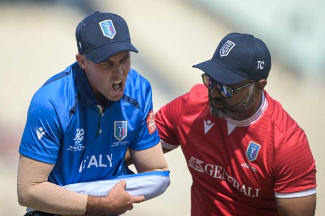Italy's captain Wayne Madsen (L) walks back to the pavilion after suffering an injury during the 2026 ICC Men's T20 Cricket World Cup group stage match between Scotland and Italy at the Eden Gardens in Kolkata on February 9, 2026. (Photo by Dibyangshu SARKAR / AFP)