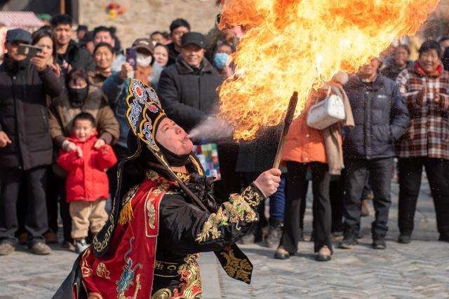 TOPSHOT - A folk performer breathes fire during a performance ahead of Lunar New Year celebrations in a village in Huai'an, in China’s eastern Jiangsu Province on February 7, 2026. (Photo by AFP) / China OUT