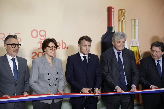 France's President Emmanuel Macron (C) cuts the ribbon as he inaugurates the Wine Paris 2026 fair next to France's Agriculture Minister Annie Genevard (2nd L), CEO of Wine Paris Rodolphe Lameyse (L), Frances junior Minister in charge of external trade Nicolas Forissier (2nd R), and President of the Paris Ile-de-France Chamber of Commerce and Industry (CCI Paris Ile-de-France) Dominique Restino (R), at the Porte de Versailles exhibition center in Paris on February 9, 2026. (Photo by Yoan VALAT / POOL / AFP)