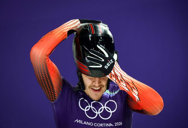 Austria's Samuel Maier puts his helmet on as he prepares to take part in the skeleton men's training session at Cortina Sliding Centre during the Milano Cortina 2026 Winter Olympic Games in Cortina d'Ampezzo on February 9, 2026. (Photo by FRANCK FIFE / AFP)