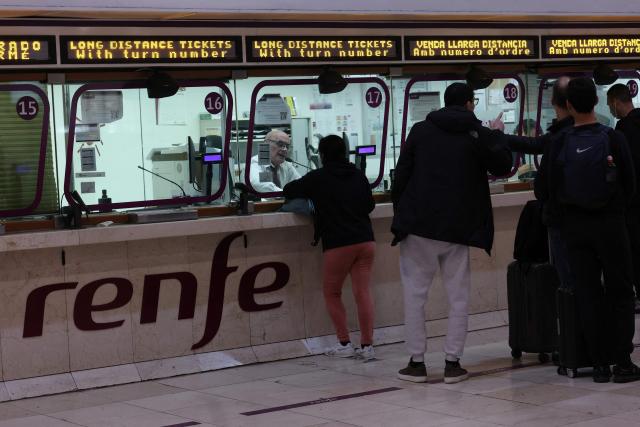 Commuters queue at Spanish national railway company's Renfe counter in Barcelona's Sants train station, on February 9, 2026, amid a national strike by Spanish train drivers' union to demand railway safety measures following deadly accidents, in Adamuz and in Gelida. Spanish train drivers began a three-day strike, demanding greater safety for their profession after two accidents claimed 47 lives last month, leaving thousands of passengers stranded. (Photo by Lluis GENE / AFP)