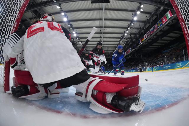 Japan's #06 Kohane Sato and Italy's #82 Kayla Tutino vie for the puck in front of Japan's #20 Miyuu Masuhara during the women's preliminary round Group B Ice Hockey match between Japan and Italy at the Milano Rho Ice Hockey Arena at the Milano Cortina 2026 Winter Olympic Games in Milan, on February 9, 2026. (Photo by Tao Xiyi / POOL / AFP)