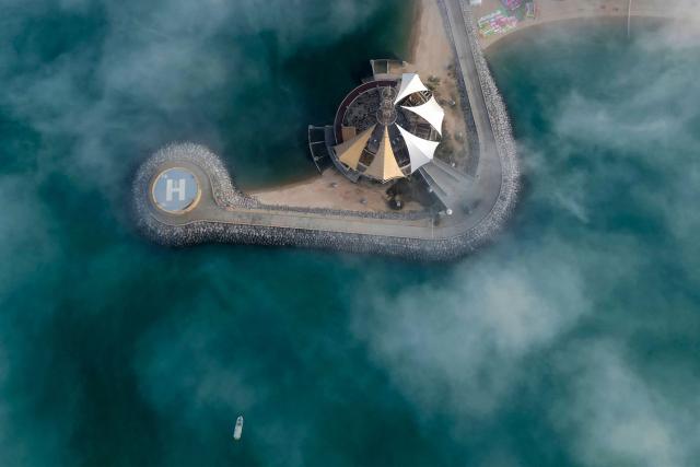 A boat sails through a veil of fog rolling over al-Salmeyya district in Kuwait City on February 9, 2026. (Photo by Yasser Al-Zayyat / AFP)