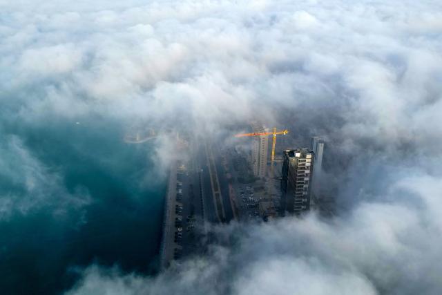 Buildings are seen through a veil of fog rolling over al-Salmeyya district in Kuwait City on February 9, 2026. (Photo by Yasser Al-Zayyat / AFP)