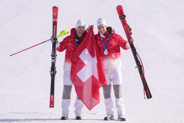 Tied Silver medallists Switzerland's Loic Meillard and Switzerland's Marco Odermatt pose after the men's team combined alpine skiing event during the Milano Cortina 2026 Winter Olympic Games at the Stelvio Ski Centre in Bormio (Valtellina) on February 9, 2026. (Photo by Dimitar DILKOFF / AFP)