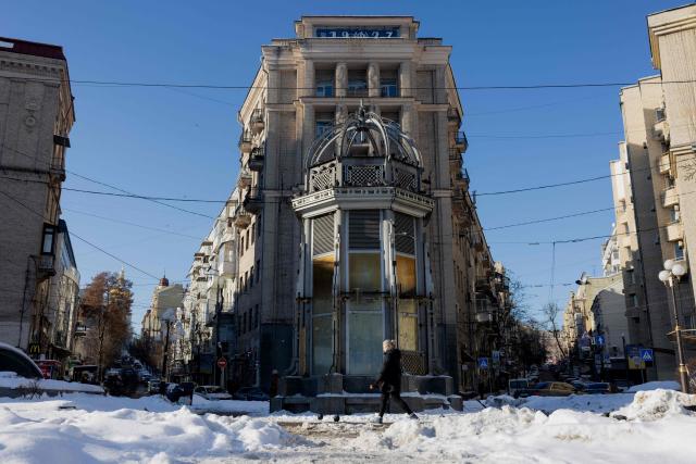 A pedestrian walks down a snow-covered street in the centre of Kyiv on February 9, 2026, amid the Russian invasion of Ukraine. (Photo by Tetiana DZHAFAROVA / AFP)