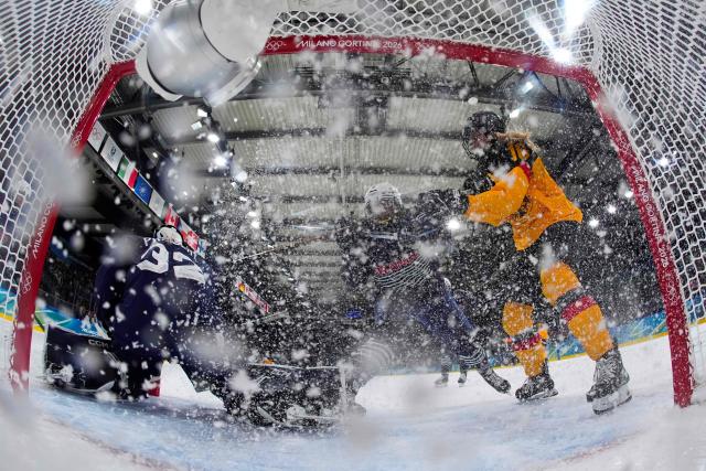 Germany's #16 Jule Schiefer (R) fights with France's #32 Alice Philbert during the women's preliminary round Group B Ice Hockey match between Germany and France at the Milano Rho Ice Hockey Arena at the Milano Cortina 2026 Winter Olympic Games in Milan, on February 9, 2026. (Photo by Darko Bandic / POOL / AFP)