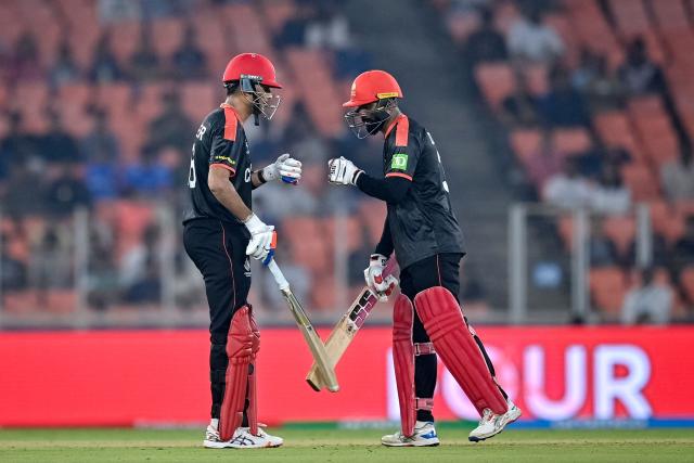 Canada's Harsh Thaker (L) and Navneet Dhaliwal bump their fists during the 2026 ICC Men's T20 Cricket World Cup group stage match between South Africa and Canada at the Narendra Modi Stadium in Ahmedabad on February 9, 2026. (Photo by Shammi MEHRA / AFP)