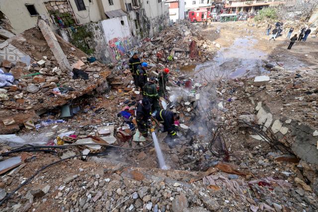 Lebanese civil defense and rescue workers search for survivors on February 9, 2026, in the rubble of an old residential building that collapsed in the Bab al-Tabbaneh neighborhood of Tripoli a day earlier. The death toll in a building collapse in the northern Lebanese city of Tripoli rose to 14 after search and rescue operations ended, the civil defence chief said on February 9. (Photo by Anwar AMRO / AFP)
