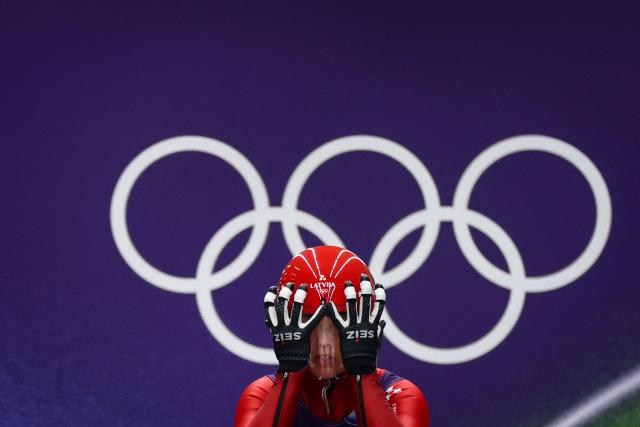 Latvia's Kendija Aparjode adjusts her helmet prior to take the start to compete in the luge women's singles run 1 at Cortina Sliding Centre during the Milano Cortina 2026 Winter Olympic Games in Cortina d'Ampezzo on February 9, 2026. (Photo by FRANCK FIFE / AFP)