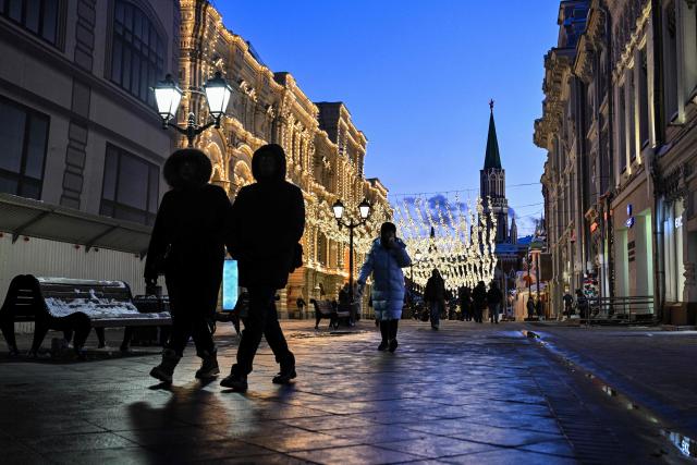 People walk on a pedestrian street near Red Square in central Moscow on February 9, 2026. (Photo by Hector RETAMAL / AFP)