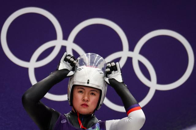 South Korea's Jung Hyesun adjusts her helmet prior to take the start to compete in the luge women's singles run 1 at Cortina Sliding Centre during the Milano Cortina 2026 Winter Olympic Games in Cortina d'Ampezzo on February 9, 2026. (Photo by FRANCK FIFE / AFP)
