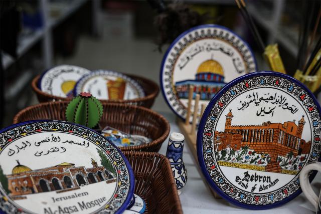 This picture shows ceramic plates, one (R) of them depicting the Ibrahimi Mosque, known to Jews as the Tomb of the Patriarchs, at a shop in Hebron's Old City, in the Israeli-occupied West Bank, on February 9, 2026. (Photo by HAZEM BADER / AFP)