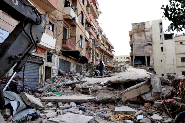 A man stands on February 9, 2026, on the rubble of an old residential building that collapsed in the Bab al-Tabbaneh neighborhood of the northern Lebanese city of Tripoli a day earlier. The death toll in a building collapse in the northern Lebanese city of Tripoli rose to 14 after search and rescue operations ended, the civil defence chief said on February 9. (Photo by Anwar AMRO / AFP)