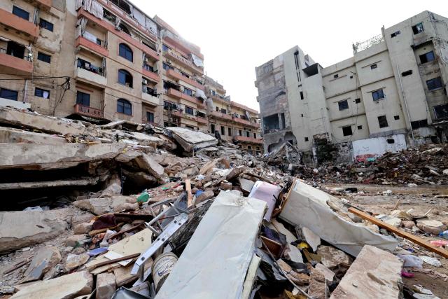 A man stands on February 9, 2026, on the rubble of an old residential building that collapsed in the Bab al-Tabbaneh neighborhood of the northern Lebanese city of Tripoli a day earlier. The death toll in a building collapse in the northern Lebanese city of Tripoli rose to 14 after search and rescue operations ended, the civil defence chief said on February 9. (Photo by Anwar AMRO / AFP)
