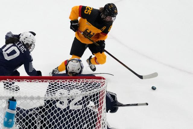 Germany's #25 Laura Kluge (R) makes an attempt on goal during the women's preliminary round Group B Ice Hockey match between Germany and France at the Milano Rho Ice Hockey Arena at the Milano Cortina 2026 Winter Olympic Games in Milan, on February 9, 2026. (Photo by Darko Bandic / POOL / AFP)