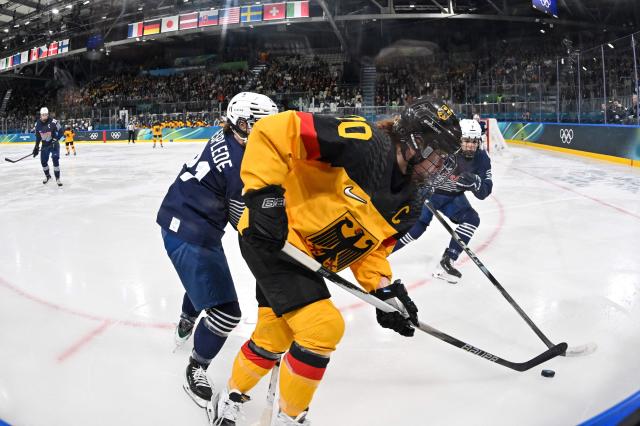 Germany's #10 Katharina Hackelsmiller (front) vies with France's #21 Julia Mesplede during the women's preliminary round Group B Ice Hockey match between Germany and France at the Milano Rho Ice Hockey Arena at the Milano Cortina 2026 Winter Olympic Games in Milan, on February 9, 2026. (Photo by Alexander NEMENOV / AFP)