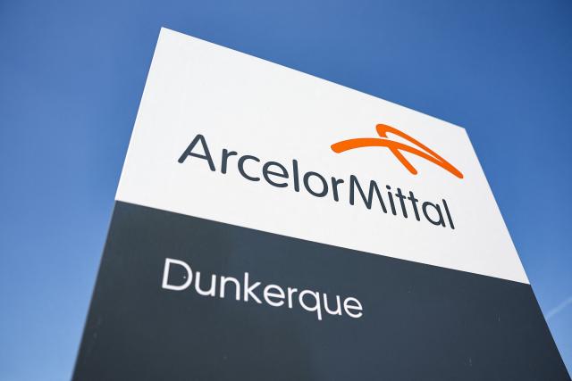 (FILES) This photograph taken on May 1, 2025, shows the logo of ArcelorMittal at the entrance of their Dunkirk site in Grande-Synthe, northern France. France's leading steel producer is expected to announce the decarbonization project for one of its plants, which will include the launch of its first electric arc furnace, during the visit of French President Emmanuel Macron on Februar 10, 2026. (Photo by Sameer Al-DOUMY / AFP)