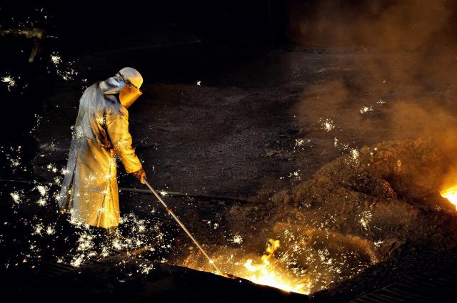 (FILES) A man works at the blast furnace of the ArcelorMittal steel plant of Grande-Synthe, northern France, on April 22, 2013. France's leading steel producer is expected to announce the decarbonization project for one of its plants, which will include the launch of its first electric arc furnace, during the visit of French President Emmanuel Macron on Februar 10, 2026. (Photo by PHILIPPE HUGUEN / AFP)
