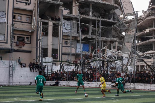 TOPSHOT - Palestinians watch a five-a-side football match amid the rubble of destroyed buildings in Gaza City on February 9, 2026. Despite a US-brokered truce that entered its second phase last month, violence has continued in the Palestinian territory, with Israel and Hamas trading accusations. (Photo by Omar AL-QATTAA / AFP)
