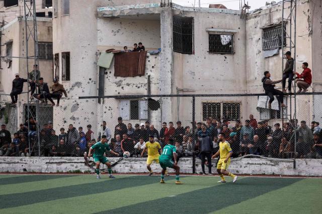 Palestinians watch a five-a-side football match amid the rubble of destroyed buildings in Gaza City on February 9, 2026. Despite a US-brokered truce that entered its second phase last month, violence has continued in the Palestinian territory, with Israel and Hamas trading accusations. (Photo by Omar AL-QATTAA / AFP)