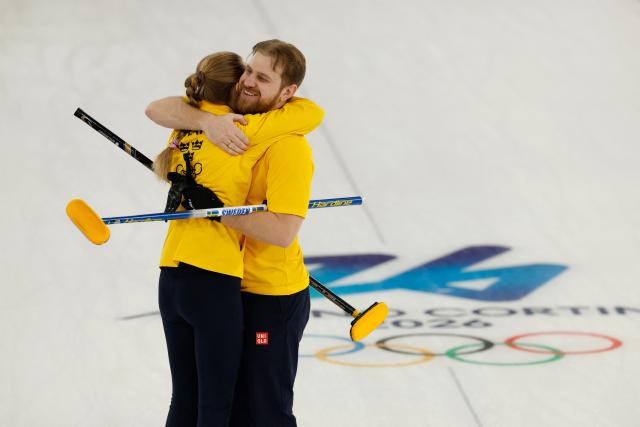 Sweden's Isabella Wranaa and Sweden's Rasmus Wrana celebrates at the end of the curling mixed doubles round robin semi-final between Great Britain and Sweden during the Milano Cortina 2026 Winter Olympic Games at the Cortina Curling Olympic Stadium in Cortina d’Ampezzo on February 9, 2026. (Photo by Odd ANDERSEN / AFP)