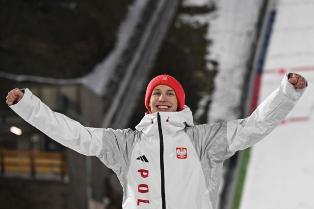 (From L) Silver medallist Poland's Kacper Tomasiak celebrates on the podium for the men's ski jumping normal hill individual final round of the Milano Cortina 2026 Winter Olympic Games at Predazzo Ski Jumping Stadium in Predazzo (Val di Fiemme), on February 9, 2026. (Photo by Javier SORIANO / AFP)