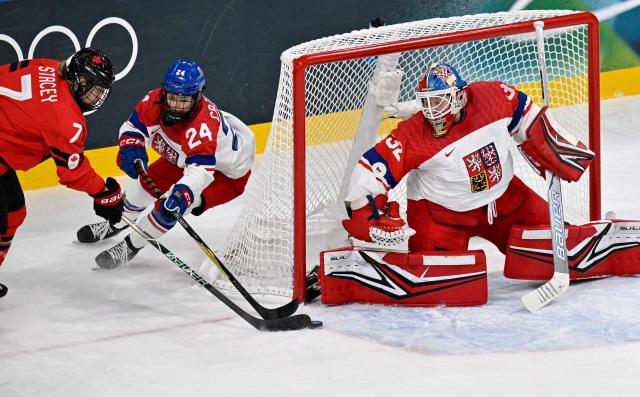 Czech Republic's #32 Julie Pejsova (R) and Czech Republic's #24 Sara Cajanova (C) vies for the puck with Canada's #07 Laura Stacey during the women's preliminary round Group A Ice Hockey match between Canada and Czech Republic at the Milano Rho Ice Hockey Arena at the Milano Cortina 2026 Winter Olympic Games in Milan, on February 9, 2026. (Photo by Alexander NEMENOV / AFP)