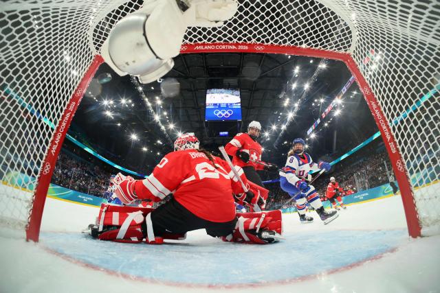 US' #08 Haley Winn (R) scores a goal past Switzerland's #20 Andrea Braendli during the women's preliminary round Group A Ice Hockey match between Switzerland and USA at the Milano Santagiulia Ice Hockey Arena at the Milano Cortina 2026 Winter Olympic Games in Milan, on February 9, 2026. (Photo by Bruce Bennett / POOL / AFP)