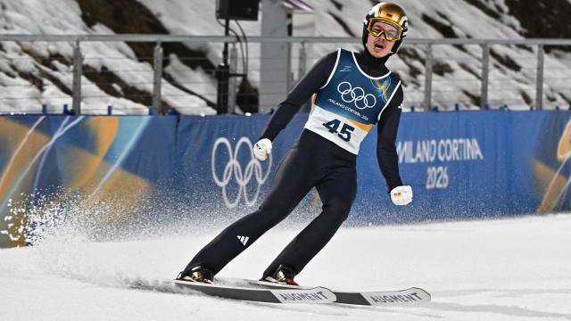 Germany's Philipp Raimund celebrates in the finish area after jumping to win the men's ski jumping normal hill individual final round of the Milano Cortina 2026 Winter Olympic Games at Predazzo Ski Jumping Stadium in Predazzo (Val di Fiemme), on February 9, 2026. (Photo by Javier SORIANO / AFP)