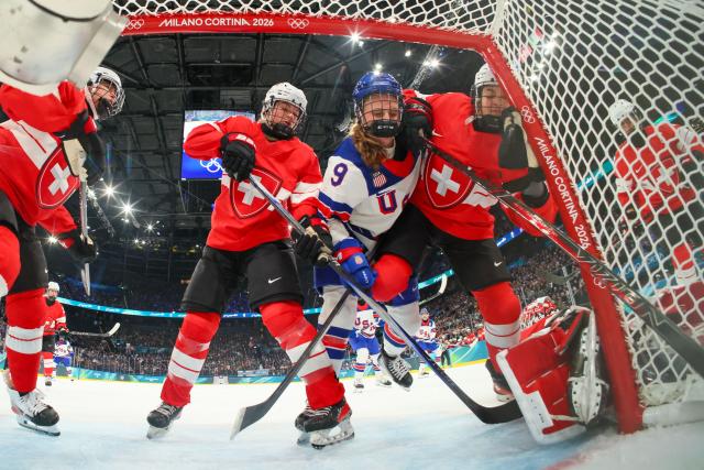 US' #09 Kirsten Simms (C) collides with Switzerland's #16 Nicole Vallario (R) during the women's preliminary round Group A Ice Hockey match between Switzerland and USA at the Milano Santagiulia Ice Hockey Arena at the Milano Cortina 2026 Winter Olympic Games in Milan, on February 9, 2026. (Photo by Bruce BENNETT / POOL / AFP)